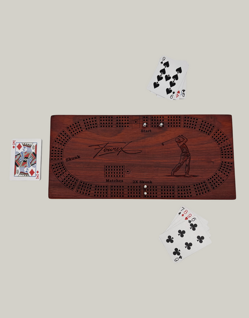 Wooden cribbage board with playing cards.